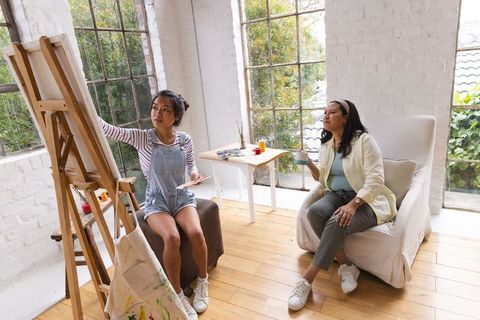 Diverse Female Artists Engaged in Vibrant Art Creation in Breezy Studio