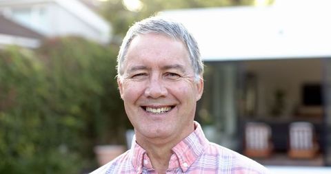 Smiling Senior Man Relaxed in Rustic Backyard Setting
