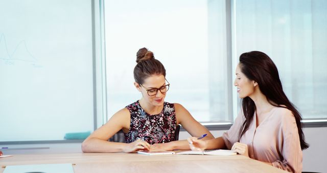 Two Businesswomen Collaborating at Meeting in Modern Office - Download Free Stock Images Pikwizard.com