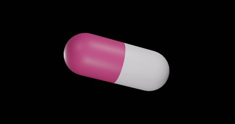 Floating pink and white capsule pill on black background