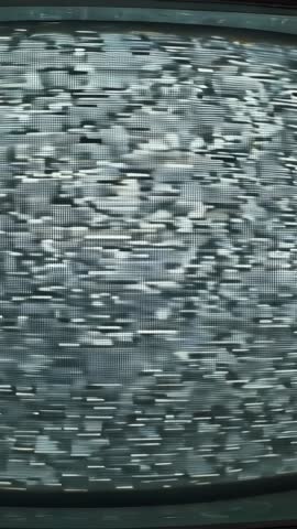 Camera zooming toward vintage CRT TV revealing static scan lines