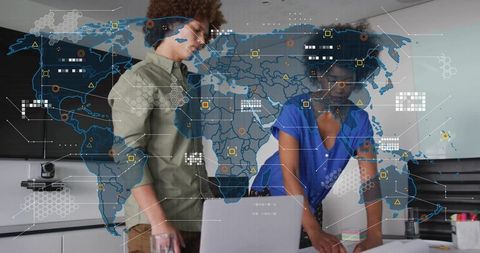 Collaborating professionals analyzing global data overlay on laptop in modern office