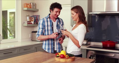 Cheerful Couple Enjoying Wine and Cooking Together in Modern Kitchen - Download Free Stock Images Pikwizard.com