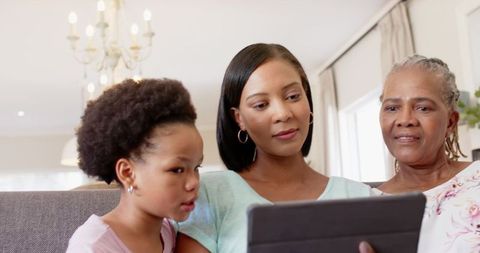 Intergenerational African American Family Relaxing on Sofa