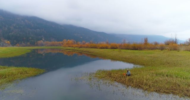 Solitary Man Fishing by Mountainous Lake in Autumn - Download Free Stock Images Pikwizard.com