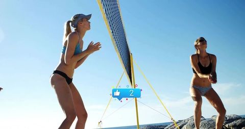 Beach Volleyball Match with Female Athletes on Rocky Shoreline