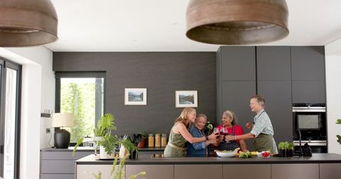 Happy Senior Female Friends Enjoying Time in Modern Kitchen