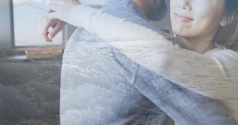 Double exposure ocean embrace: couple hugging by window with soft light overlay