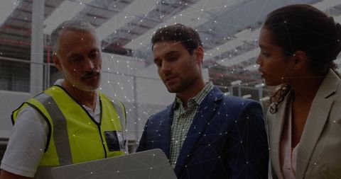 Warehouse team collaborating on logistics strategy with digital assistance