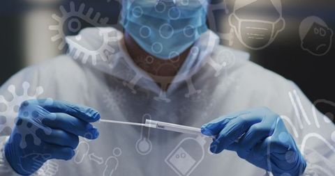 Doctor in protective gear holding covid-19 test swab