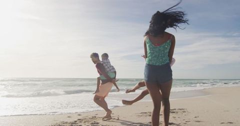Happy Family Playing at Beach With Children in Sunny Weather