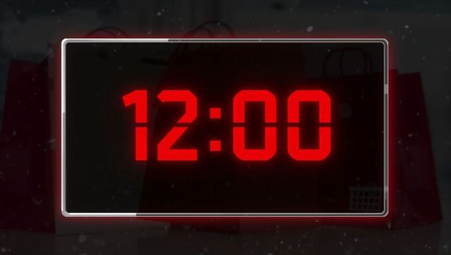 Red led digital clock showing 12:00 on glossy black panel with chrome bezel