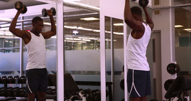 Young Man Lifting Weights at Gym Mirror Reflection - Download Free Stock Images Pikwizard.com