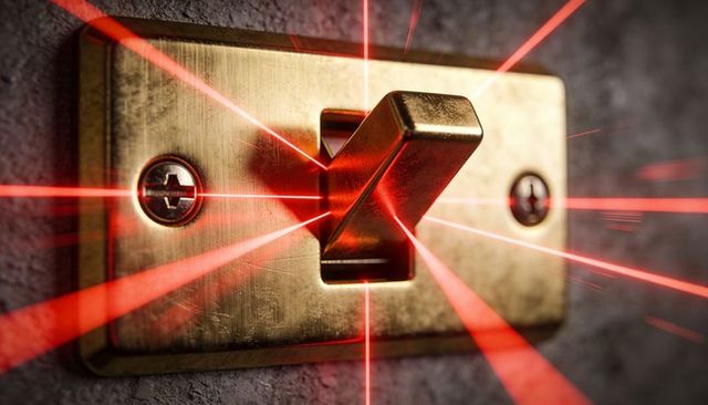 Brass toggle switch radiating red laser beams closeup on textured gray wall