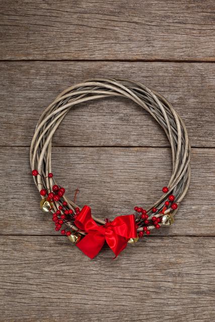 Grapevine wreath with red ribbon on a plank