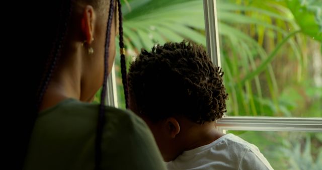 Mother and Child Looking Out Window with Green Plants - Download Free Stock Images Pikwizard.com