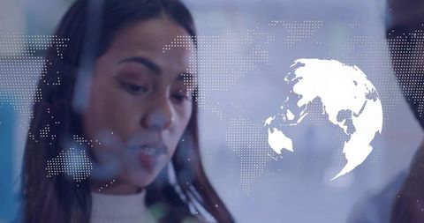 Tech Professional Examining Digital Interface with World Map Overlay