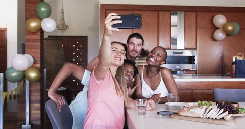 Diverse Friends Taking Selfie in Kitchen Celebrating Togetherness