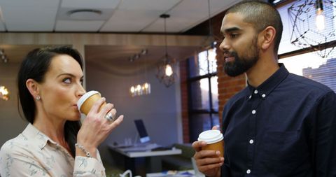 Diverse Business Professionals Engaging Over Coffee in Modern Office