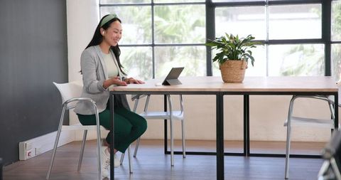 Woman Having Video Call on Tablet in Modern Office