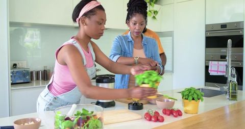 African american family preparing healthy meal together in bright modern kitchen