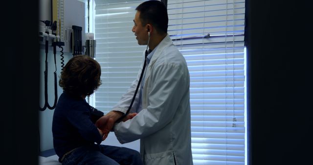 Pediatrician performing routine check-up on young boy in doctor’s office. Ideal for use in health-related articles, pediatric care promotions, and educational materials about medical professions.