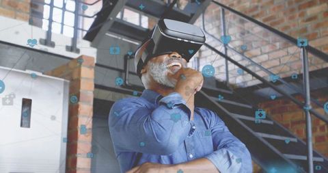 Senior Man Using VR Headset Exploring Virtual Reality World in Modern Loft