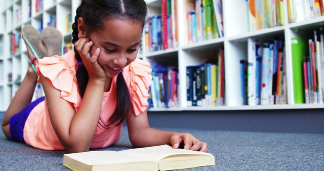 Young Girl Reading Book on Library Floor Smiling Happily - Download Free Stock Images Pikwizard.com