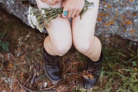 Woman Holding White Wildflowers in Outdoor Setting