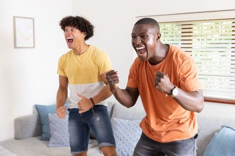 Excited Friends Celebrating Victory in Modern Living Room