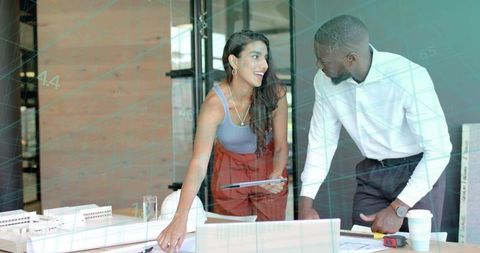 Two Professionals Analyzing Blueprints for Collaborative Project