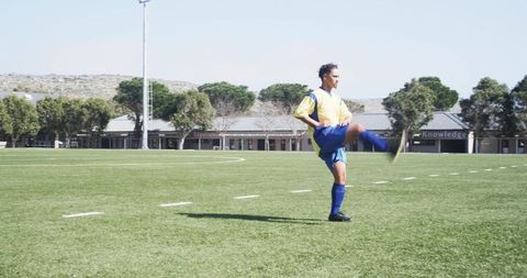 Soccer player practicing kicks on sunny outdoor field
