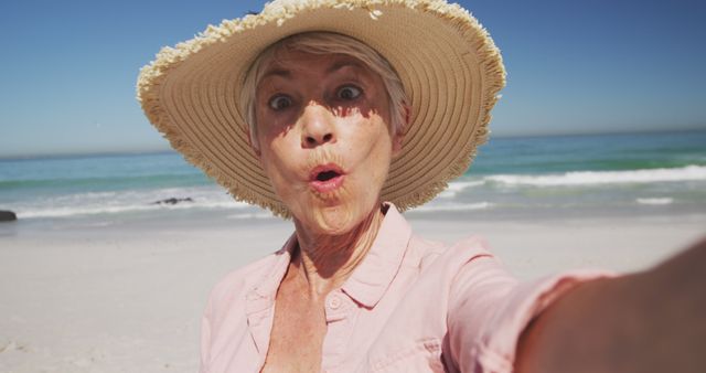 Happy senior caucasian woman taking selfie on beach. Senior lifestyle, realxation, nature, communication, free time and vacation.