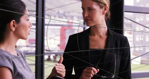 Businesswomen in networked office environment discussing strategies