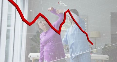 Therapist guiding client through assisted stretch with downward financial chart overlay