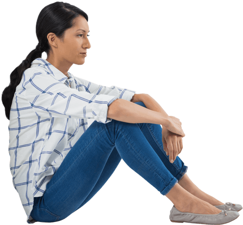 Thoughtful woman sitting in casual wear on transparent surface