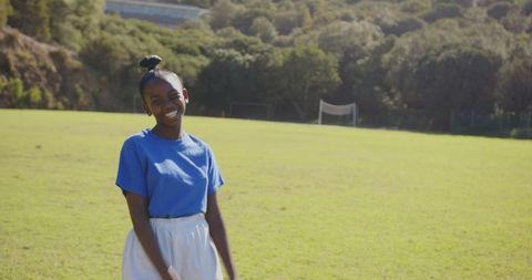 Smiling Youth in Vibrant Sportswear on Sunny Athletic Field