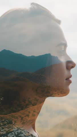 Vertical double exposure of woman merging with mountain peaks, meditative scenic portrait