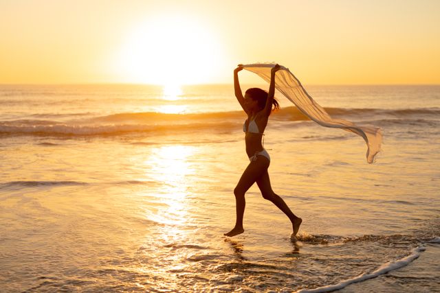 Woman in bikini running with scarf on the beach - Download Free Stock Photos Pikwizard.com