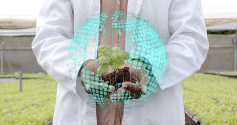 Scientist studying plant growth with digital globe overlay in greenhouse