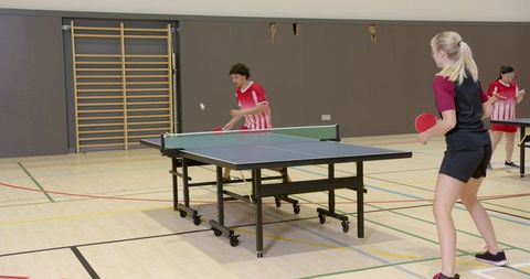 Table tennis team players competing indoors