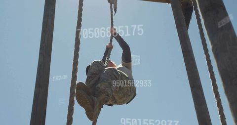 Female Soldier Climbing Rope in Outdoor Obstacle Training