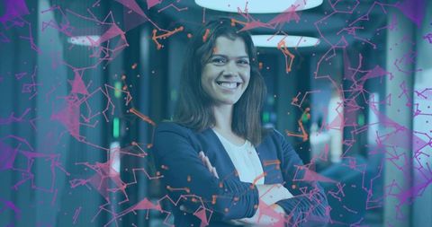 Smiling female executive standing with arms crossed in modern office with digital network overlay
