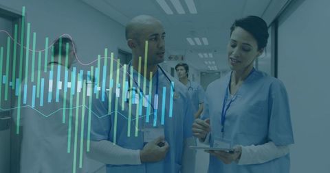 Diverse Medical Team Analyzing Digital Data in Hospital Corridor