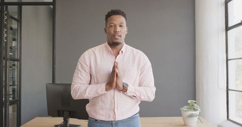 Confident businessman in casual attire greeting in modern office