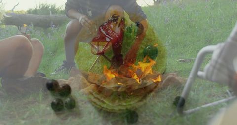 Campers gathering around fire pit in tranquil outdoor setting