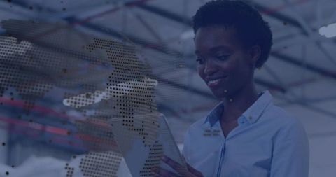 Woman engineer using tablet in smart warehouse with digital world map overlay