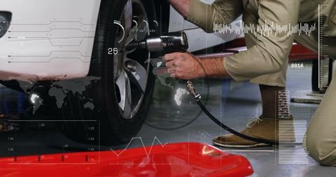 Kneeling mechanic tightening wheel lug nuts with pneumatic impact wrench and HUD overlays