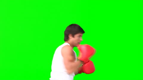 Man Practising Kickboxing with Red Gloves on Green Background