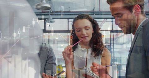 Business Team Collaborating in Modern Office with Financial Graphics